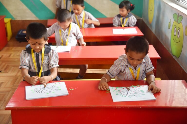 Kindergarten children making a paper collage in class