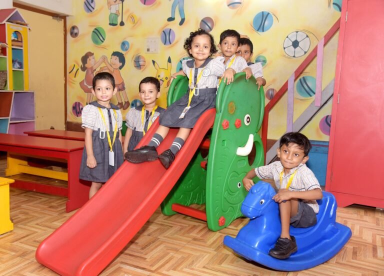 Nursery children on the indoor slide and rocking horse in the play corner