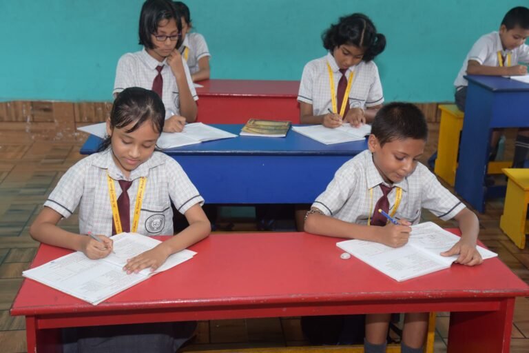 Primary pupils writing at their desks in a classroom