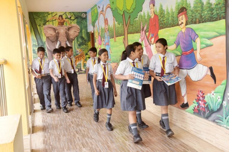 Pupils walking and talking along the mural-painted school corridor