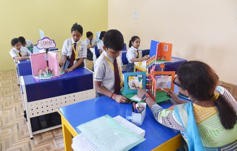Teacher looking at a pupil's project model in class