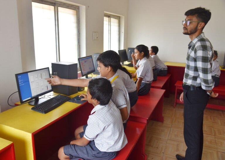 Pupils working together at a computer in the school computer lab