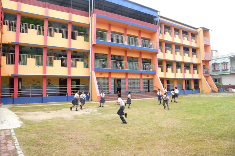 Children running on the lawn in front of the main school building