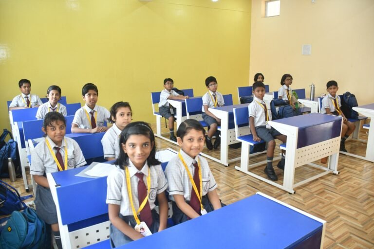 Pupils smiling at their desks in a classroom
