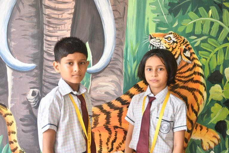 Two pupils in front of a jungle mural