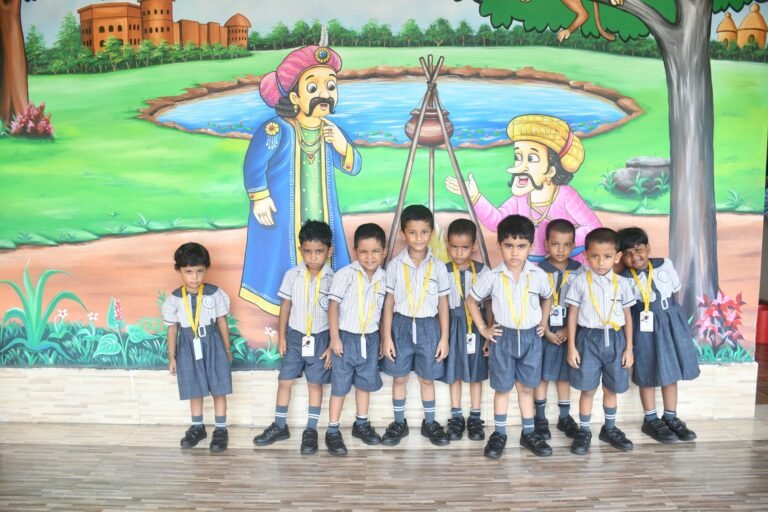Kindergarten children standing in a row in front of a corridor mural